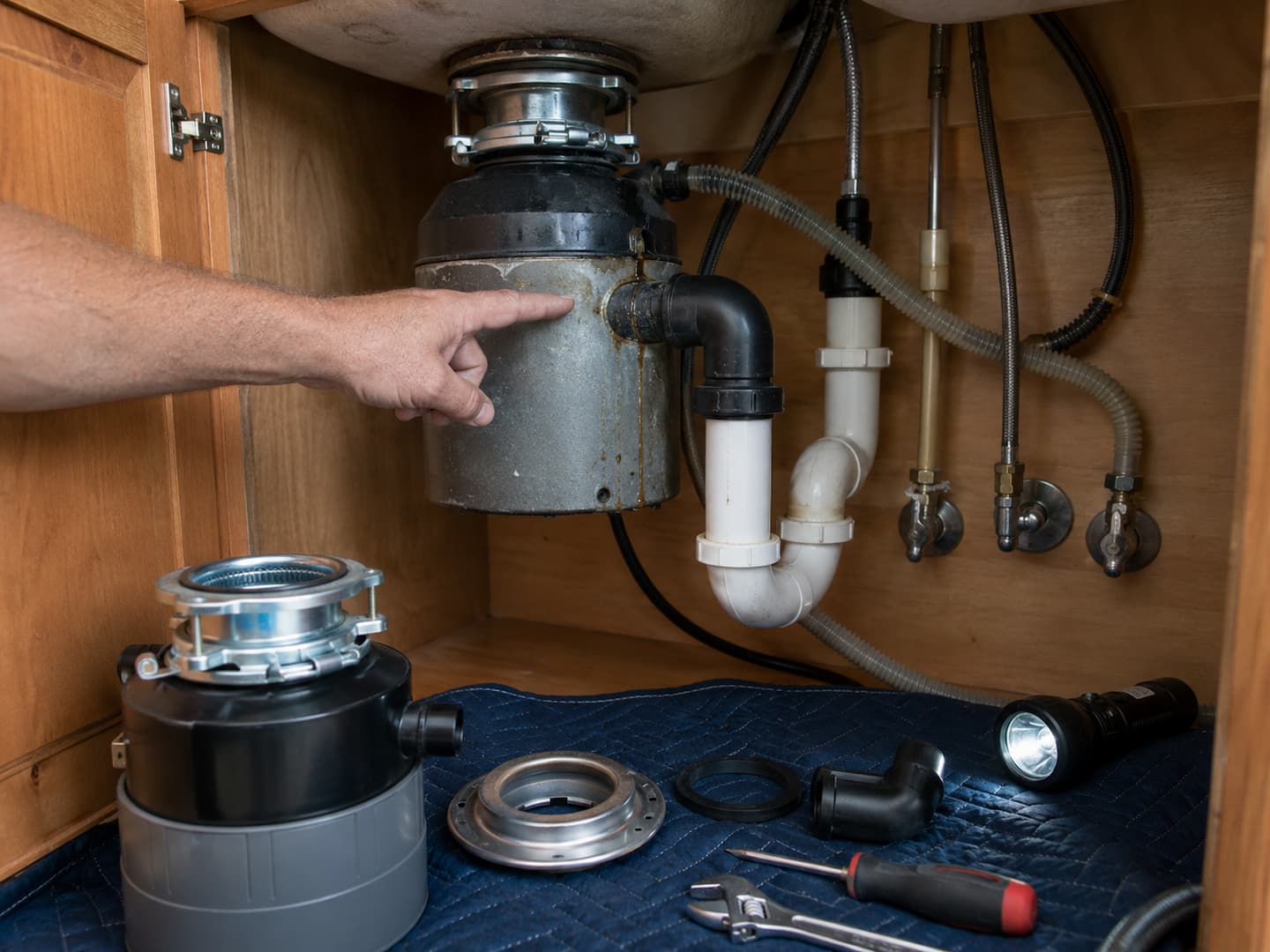 Plumber evaluating whether a garbage disposal should be repaired or replaced