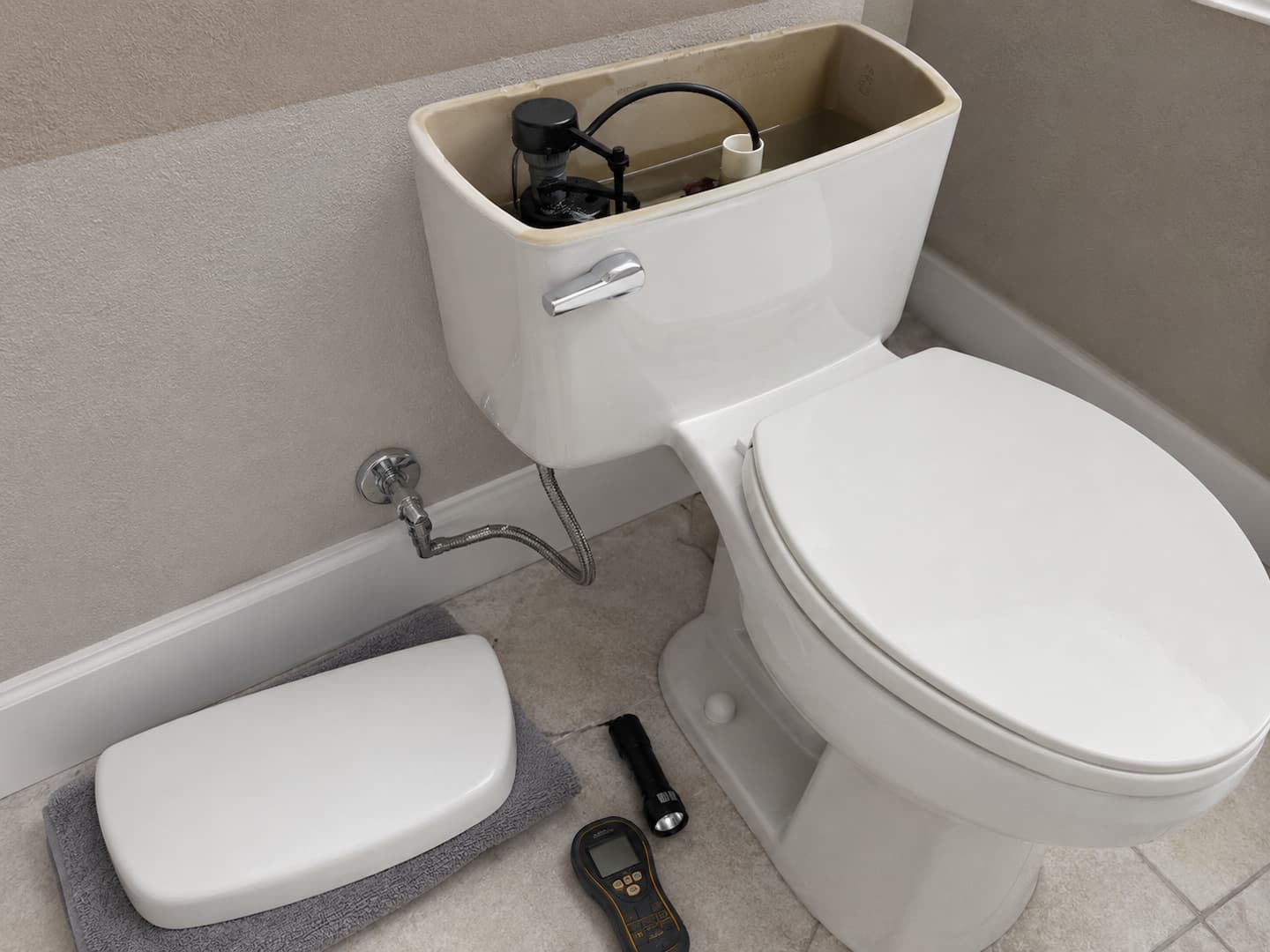 Residential plumber inspecting toilet connections and bathroom plumbing components