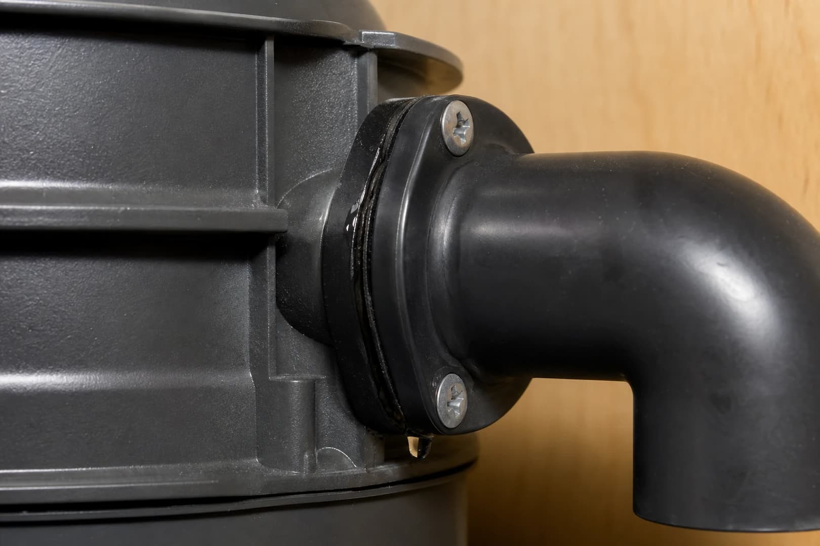 Close-up of a small water leak at a garbage disposal discharge elbow gasket