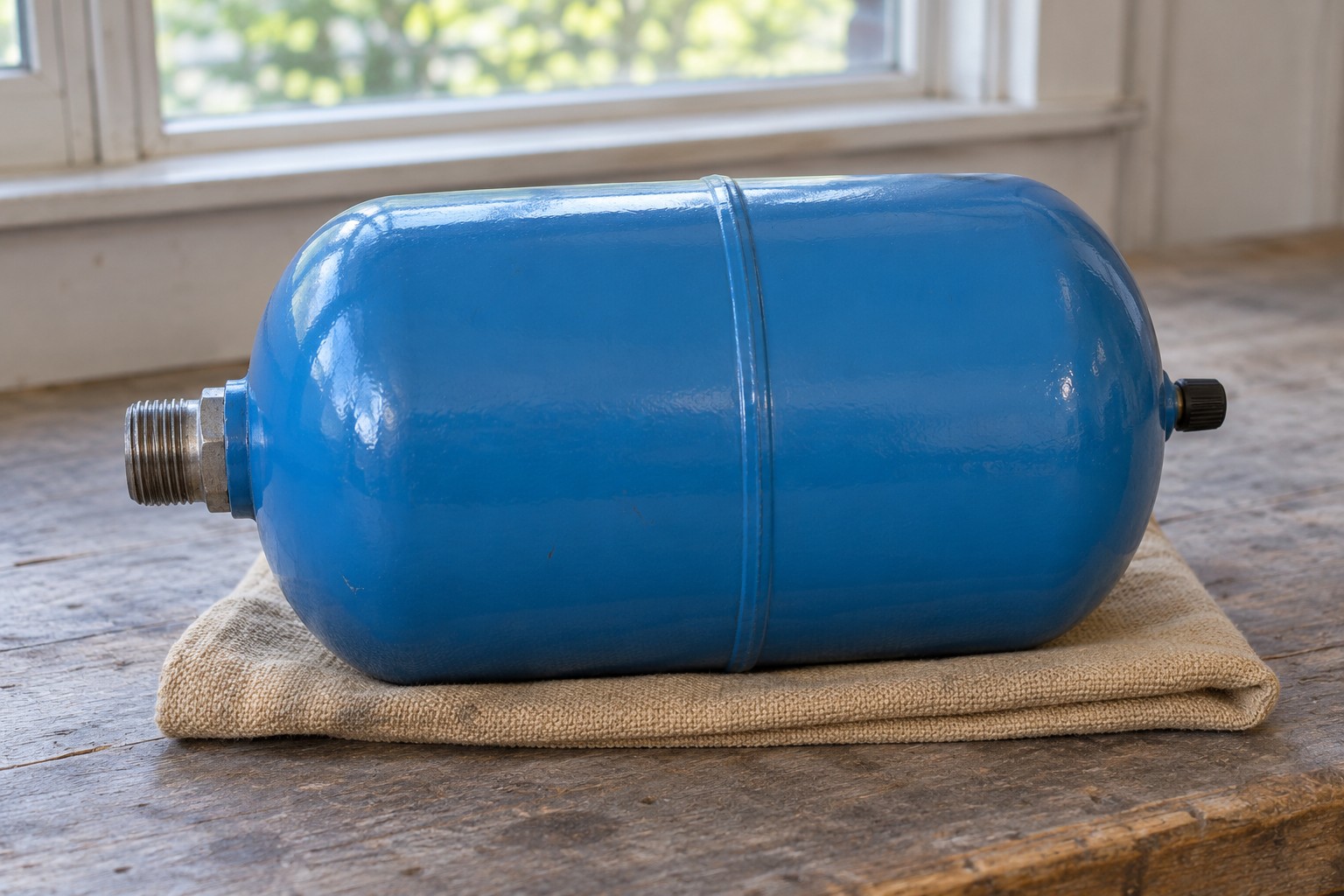 Detached intact thermal expansion tank resting on a workbench