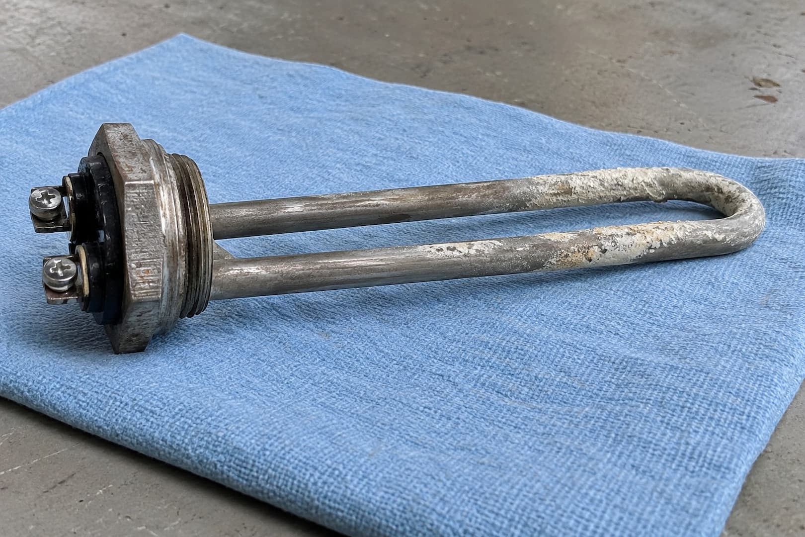 Removed U-shaped electric water heater element with mineral scale on its surface